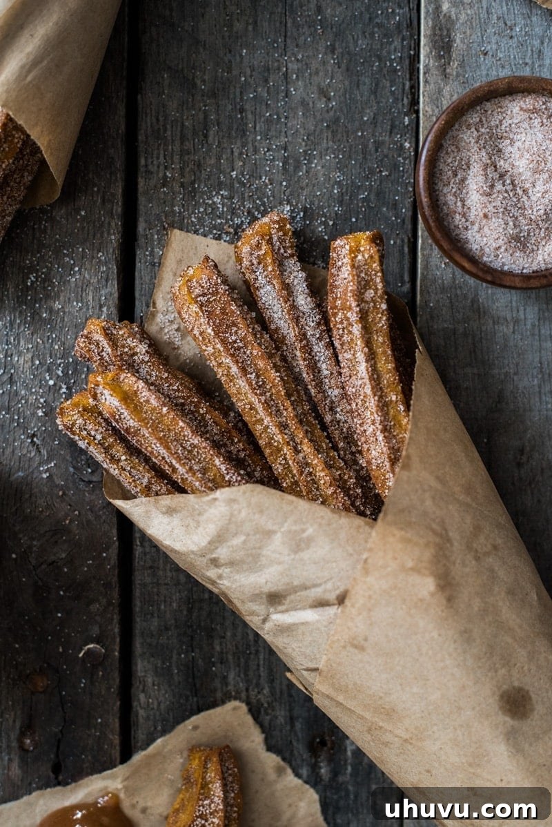 Delicious Baked Pumpkin Churros coated in cinnamon sugar, perfect for a fall or winter treat. These churros are baked, not fried, allowing for a lighter indulgence.