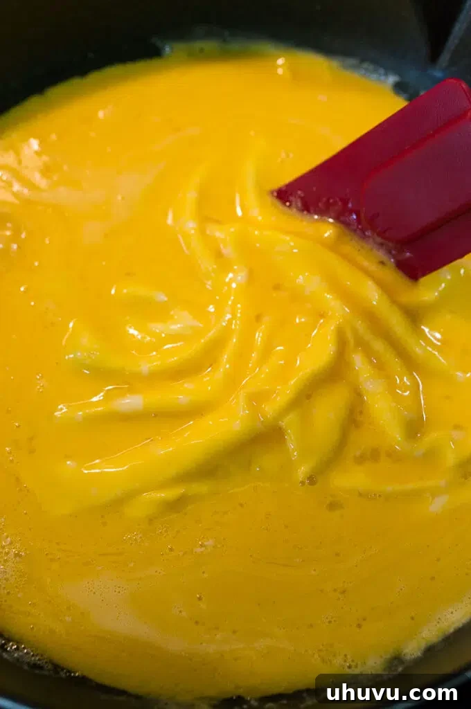 fluffy scrambled eggs cooking in a pan