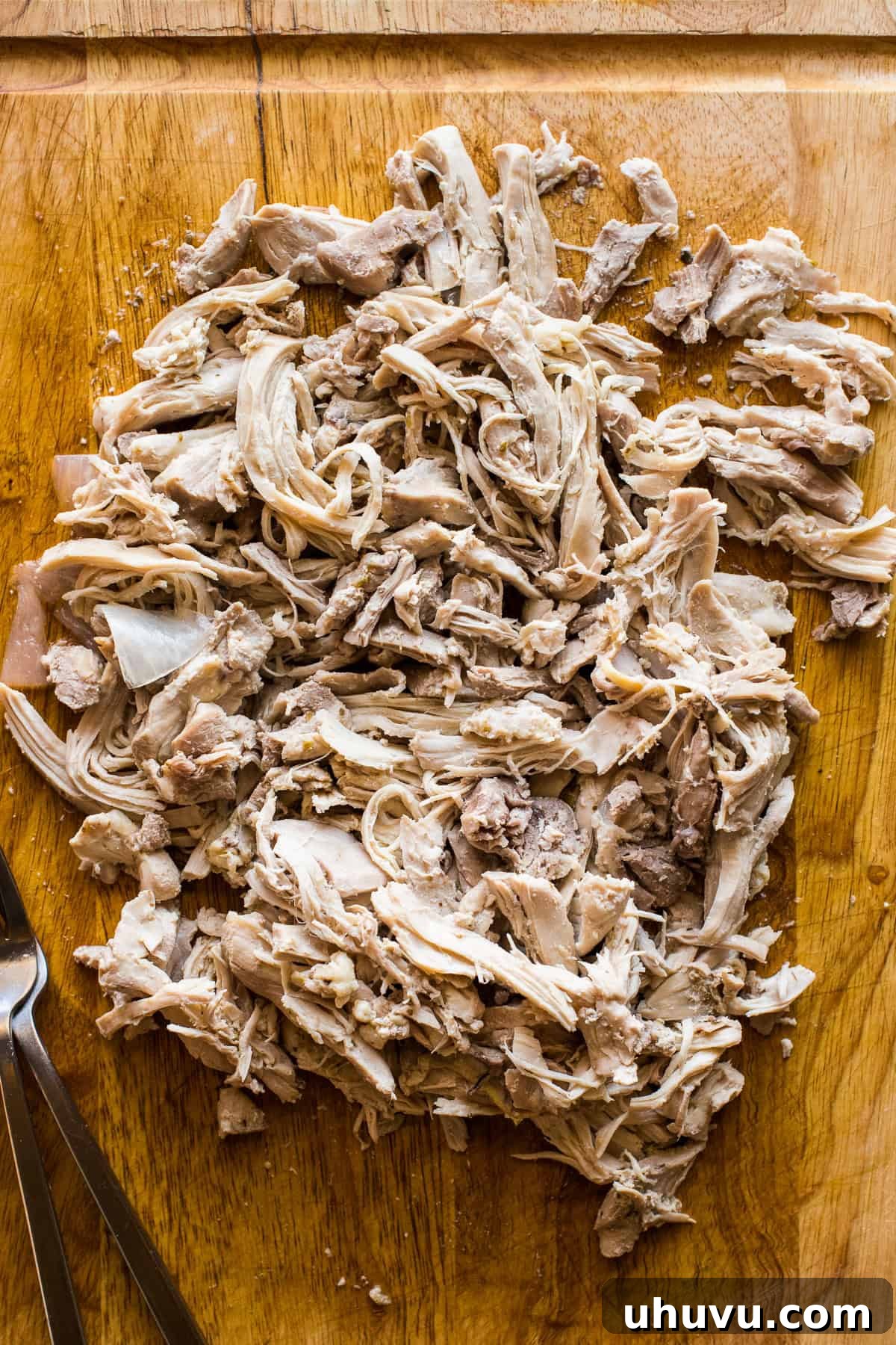 Vibrant Green Pozole 5 A cutting board with cooked shredded chicken for chicken pozole verde.