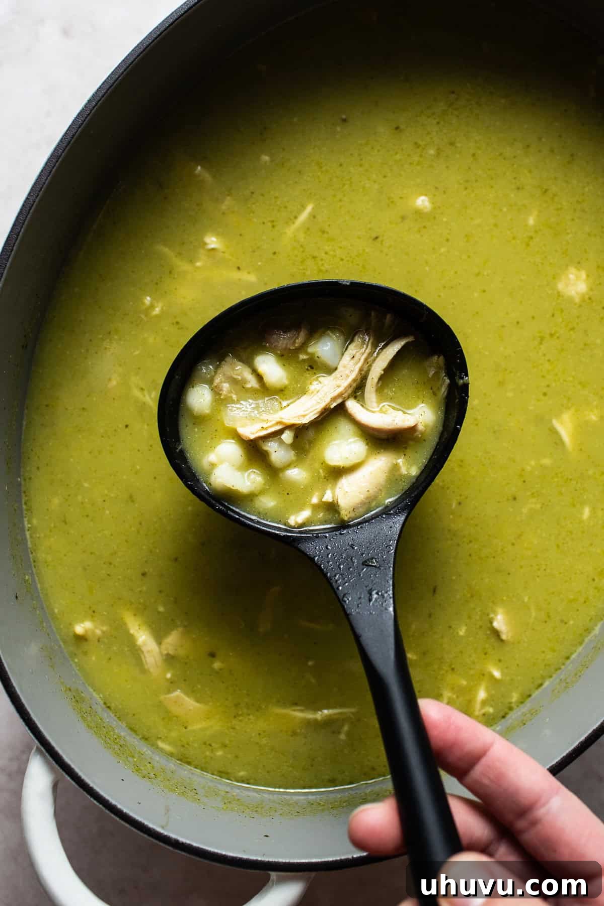 Vibrant Green Pozole 7 Cooked pozole verde in a large pot with a ladle spooning out some of the soup.