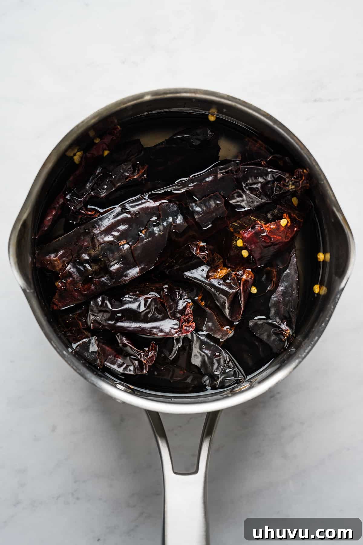 Sunrise Salsa Crunch 4 Guajillo and arbol chiles soaking in a pot of hot water.