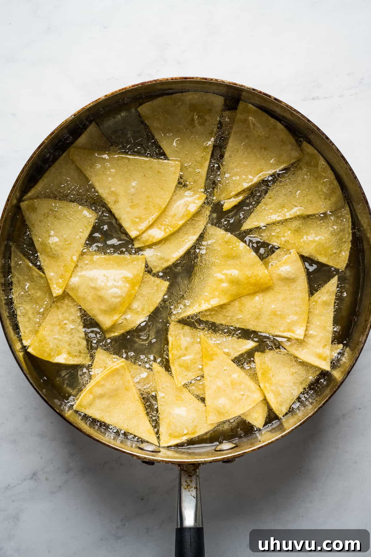 Sunrise Salsa Crunch 8 Corn tortilla chips frying in hot oil.
