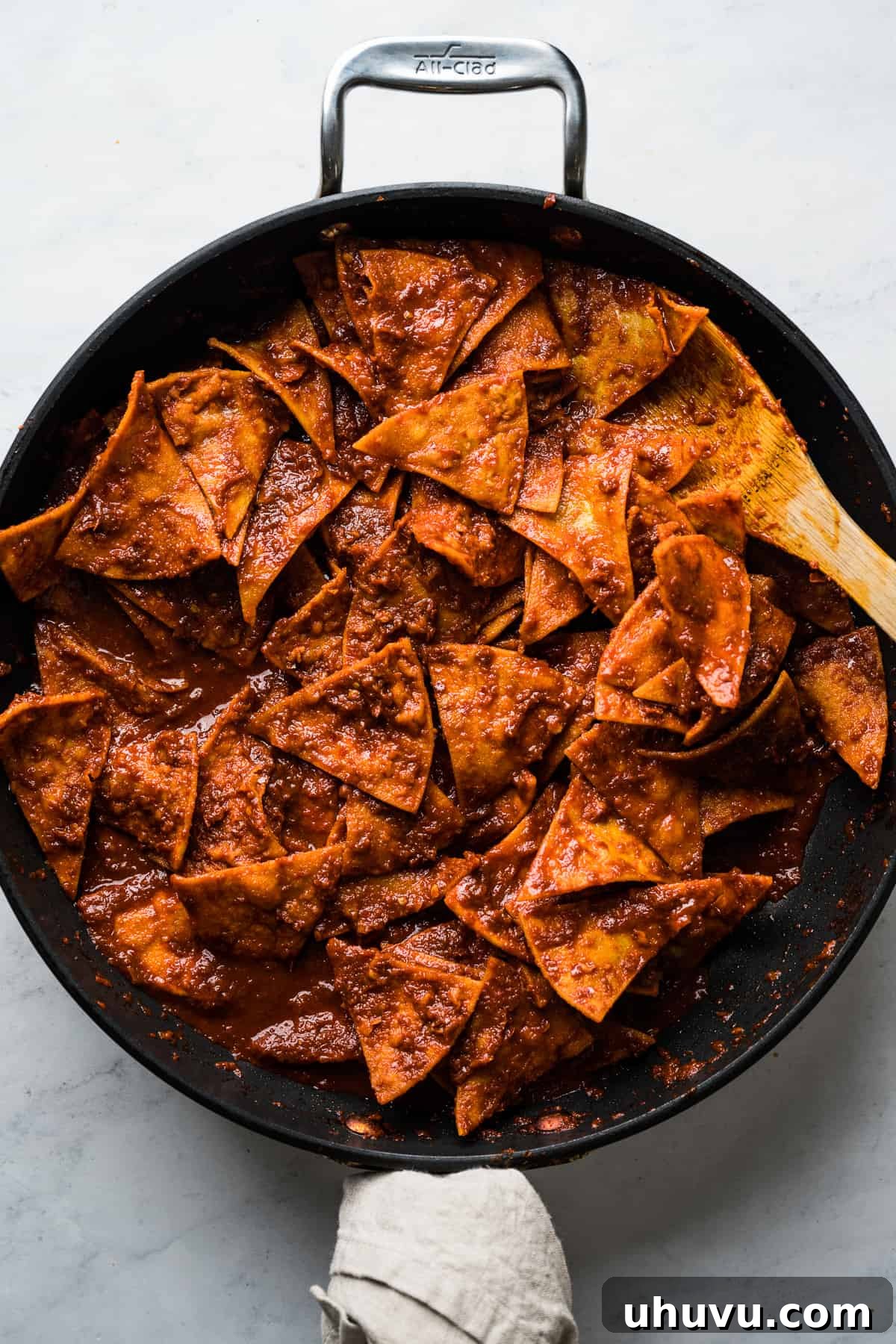 Sunrise Salsa Crunch 10 Fried tortilla chips being tossed in a red sauce to make chilaquiles.