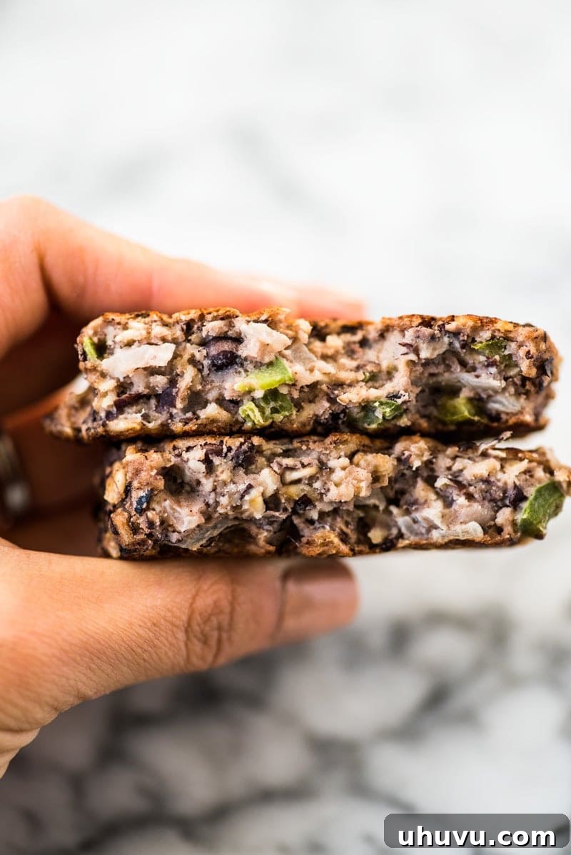 A close-up view of the inside of a perfectly cooked black bean patty, revealing its creamy texture and visible black beans and oats.
