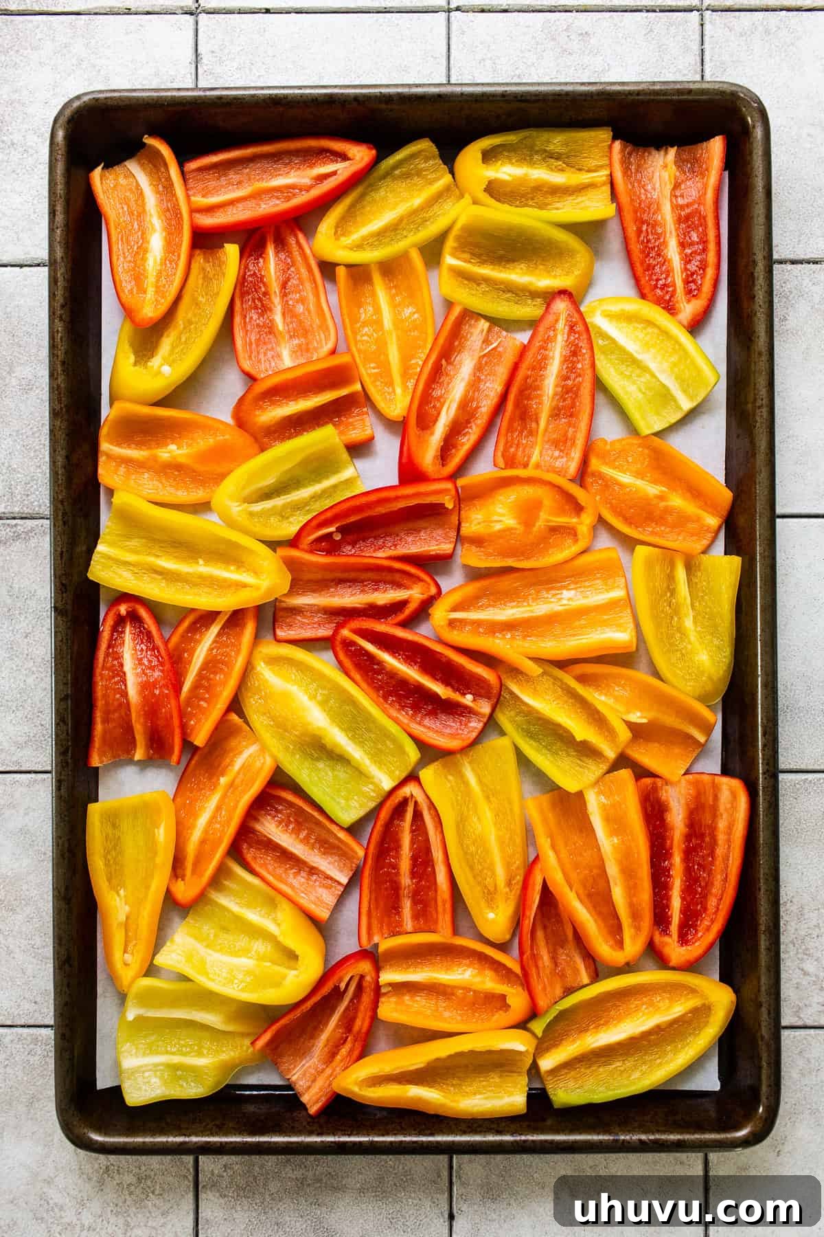 Rainbow Pepper Nachos 6 Mini bell peppers carefully sliced in half lengthwise and arranged in a single layer on a parchment-lined baking sheet, ready for filling.