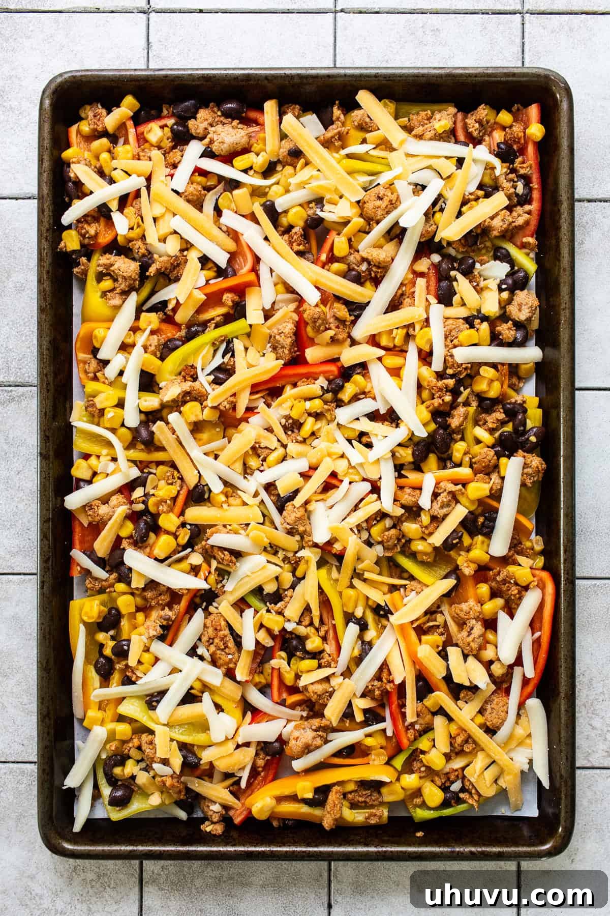 Rainbow Pepper Nachos 7 Bell pepper halves on a sheet pan, generously topped with the savory meat and bean mixture, then covered with a generous layer of shredded cheese.