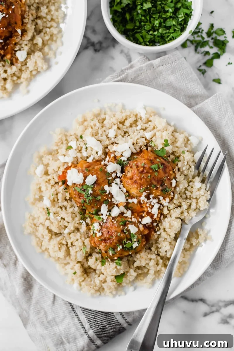 Flavorful Gluten Free Enchilada Chicken Meatballs 6 Overhead view of gluten-free chicken meatballs with enchilada sauce, cilantro, and cheese, ready to be enjoyed.