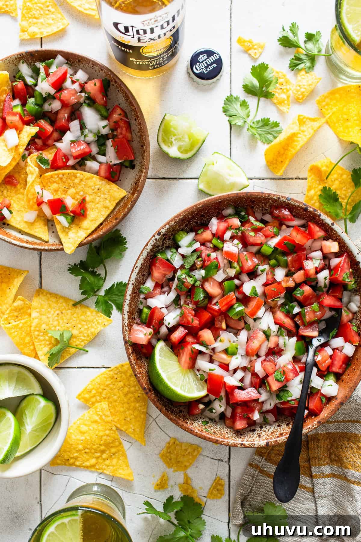 Fresh Salsa Fiesta 6 Pico de gallo served in a rustic bowl, accompanied by golden tortilla chips and fresh lime wedges, ready for enjoyment.