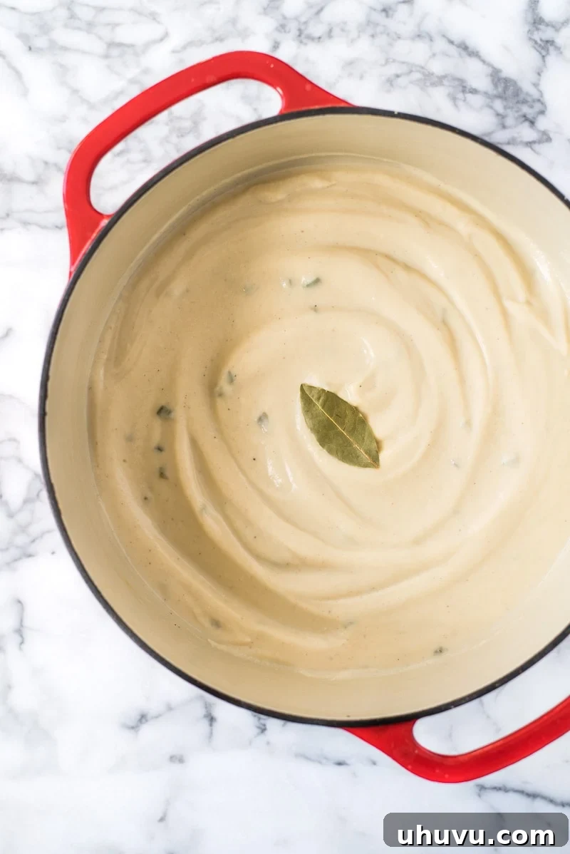 Close-up of the rich, creamy texture of Roasted Cauliflower Soup, topped with vibrant fried jalapeños, showcasing its vegan and gluten-free appeal.