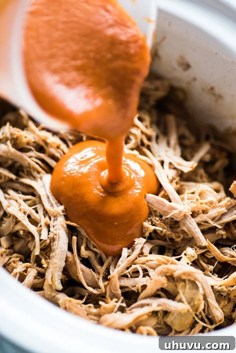 Close-up of Slow Cooker BBQ Pulled Pork Tacos garnished with fresh cilantro, showing the juicy pork and creamy coleslaw.