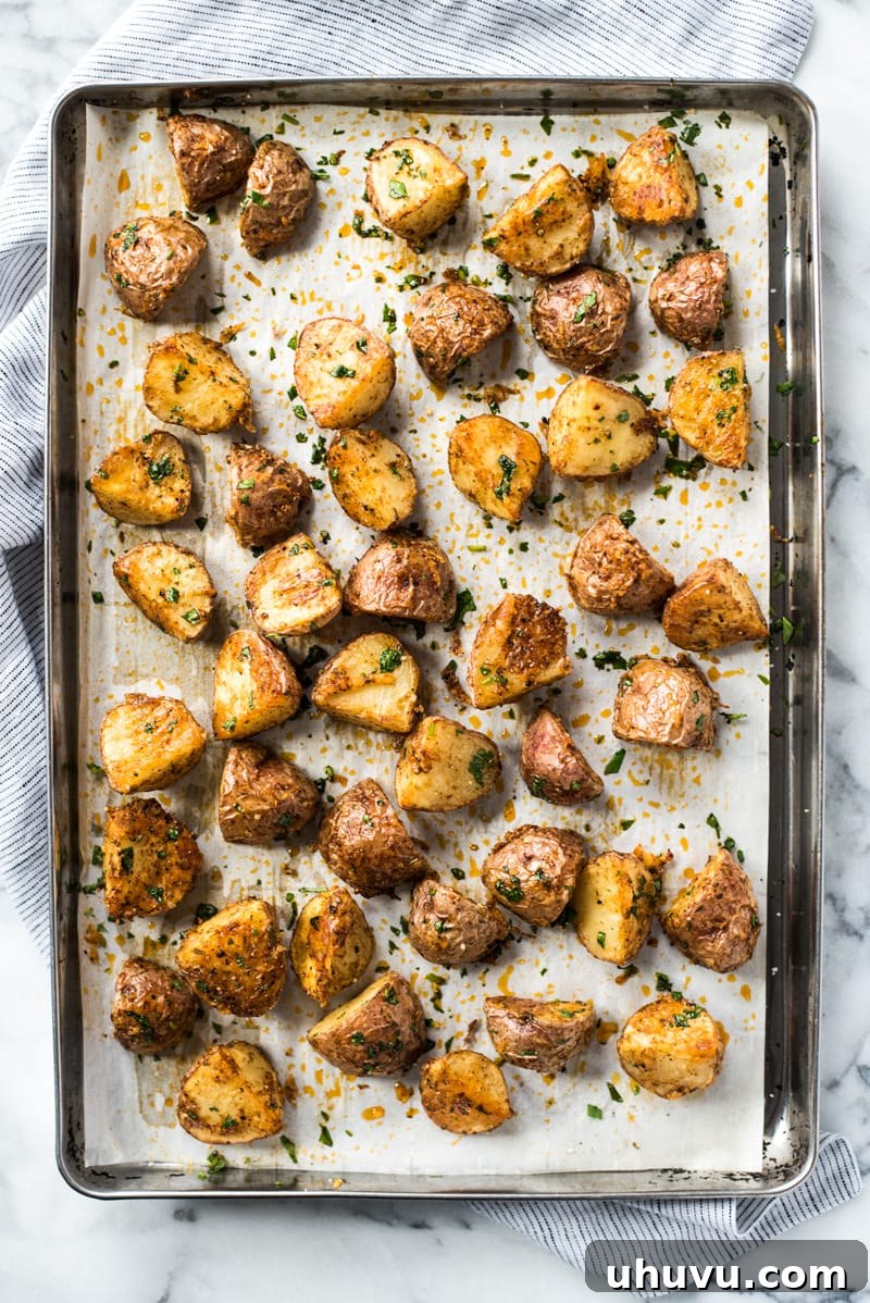 Spicy Mexican Spuds 4 A large baking sheet filled with a generous batch of baked Mexican potatoes, perfectly crispy and golden.