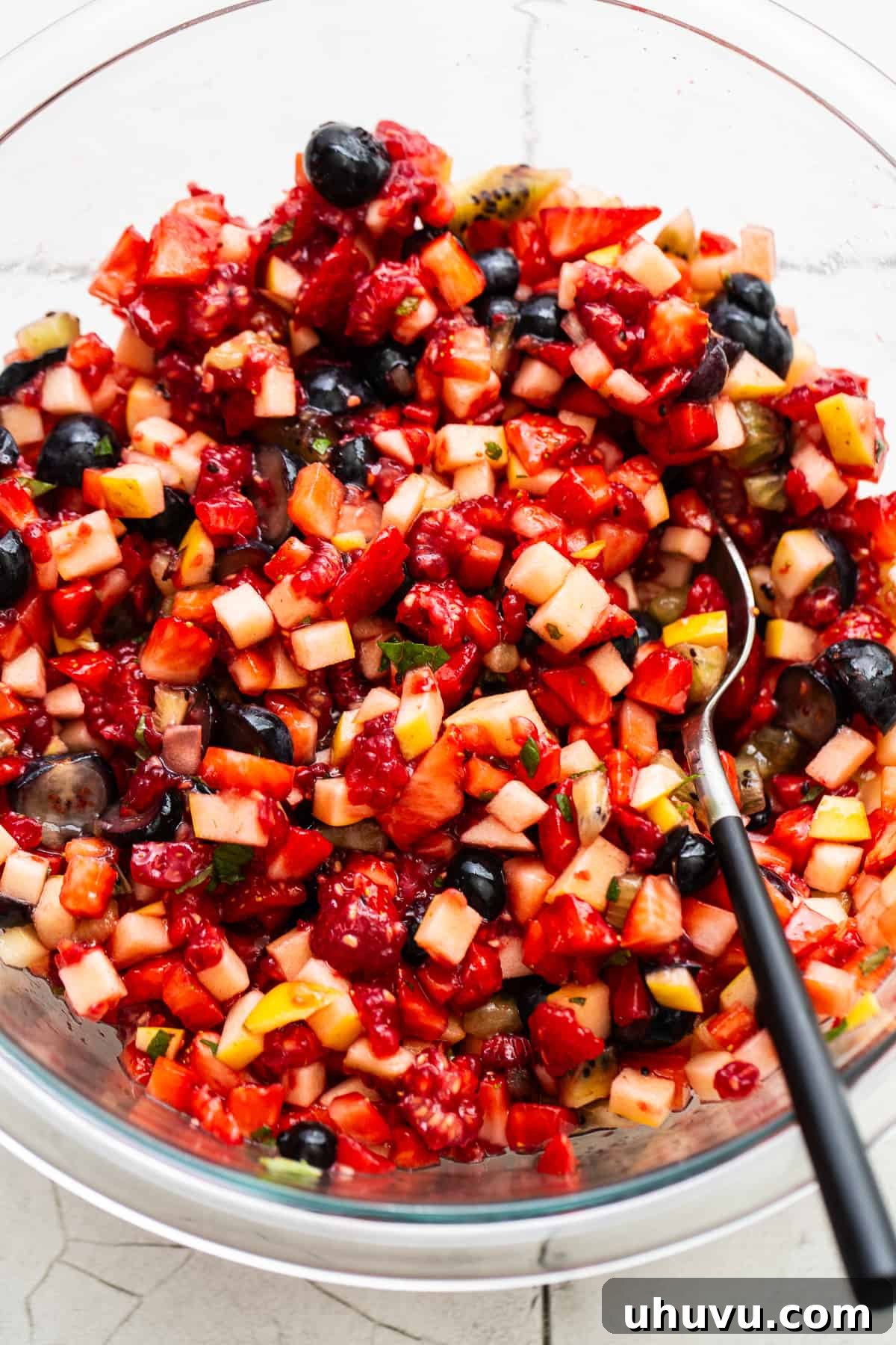Vibrant Fruit Salsa 4 Finely diced fruit salsa in a mixing bowl with a serving spoon.