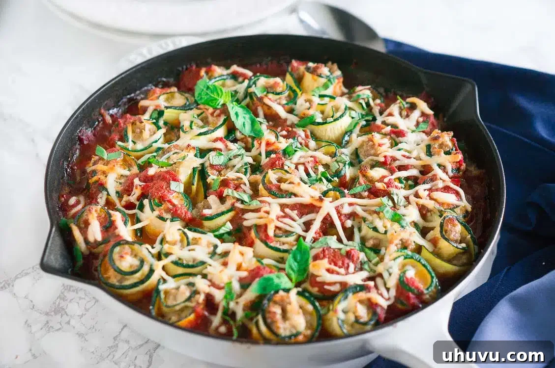 Close-up of freshly prepared Zucchini Lasagna Roll-Ups in a skillet, showcasing the melted cheese and marinara sauce.