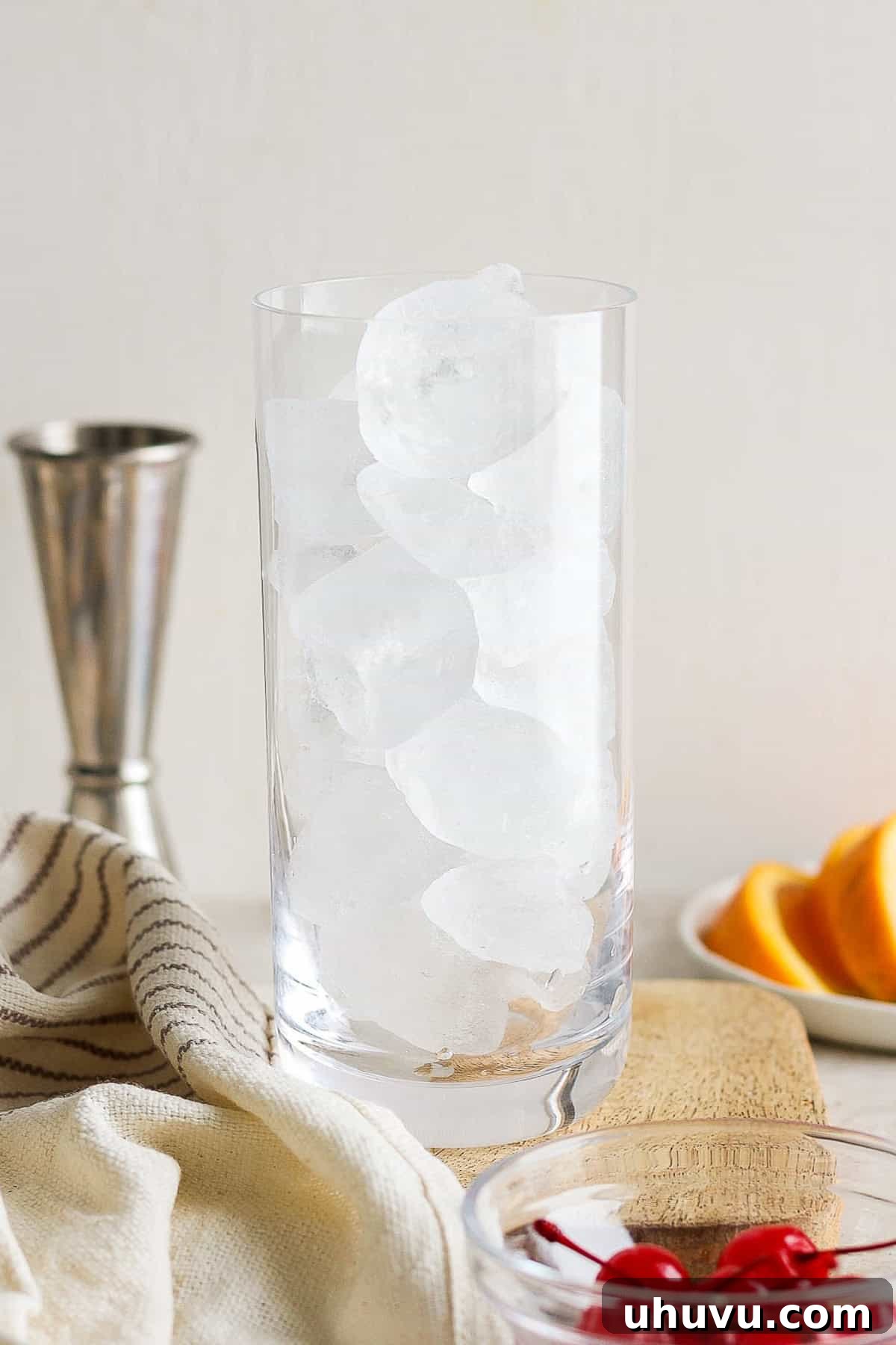 Liquid Dawn 4 A highball glass meticulously filled with ice cubes, ready for cocktail preparation.