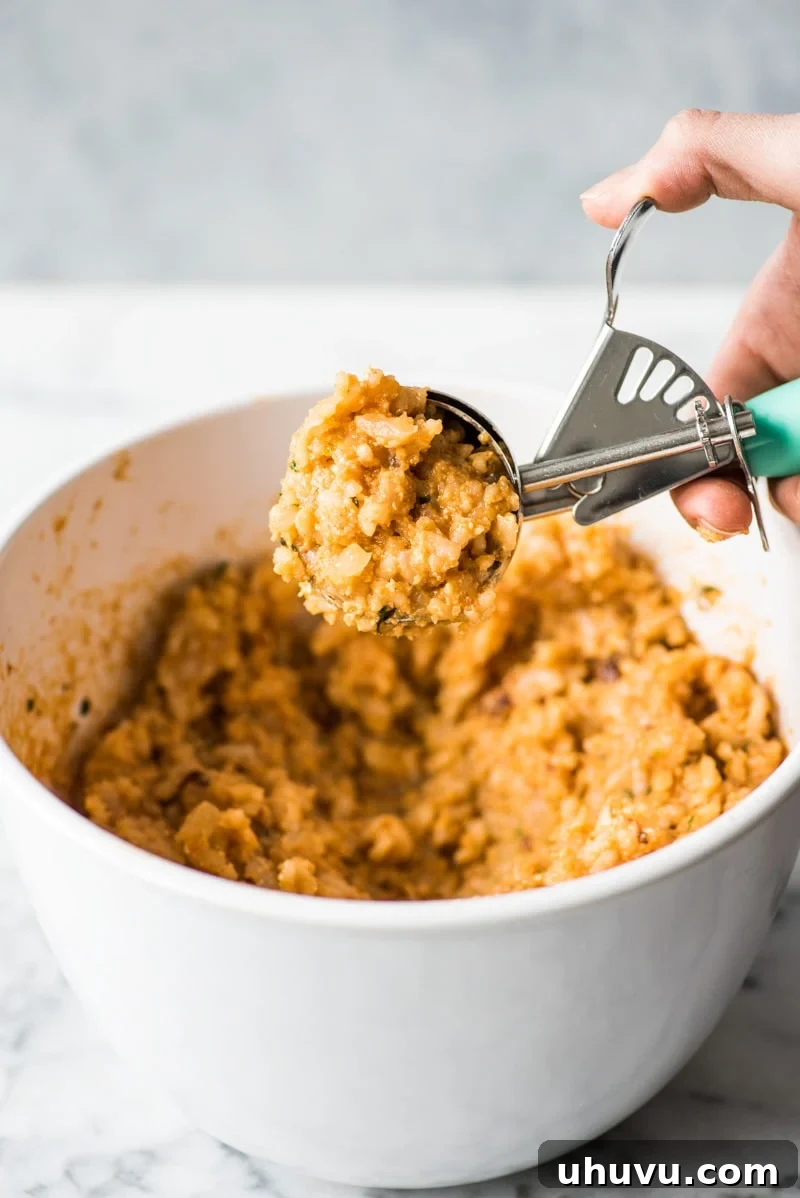 Zesty Fiesta Rice Bites 3 Scooping the cooled Mexican risotto rice mixture onto a clean surface to begin forming the arancini balls.