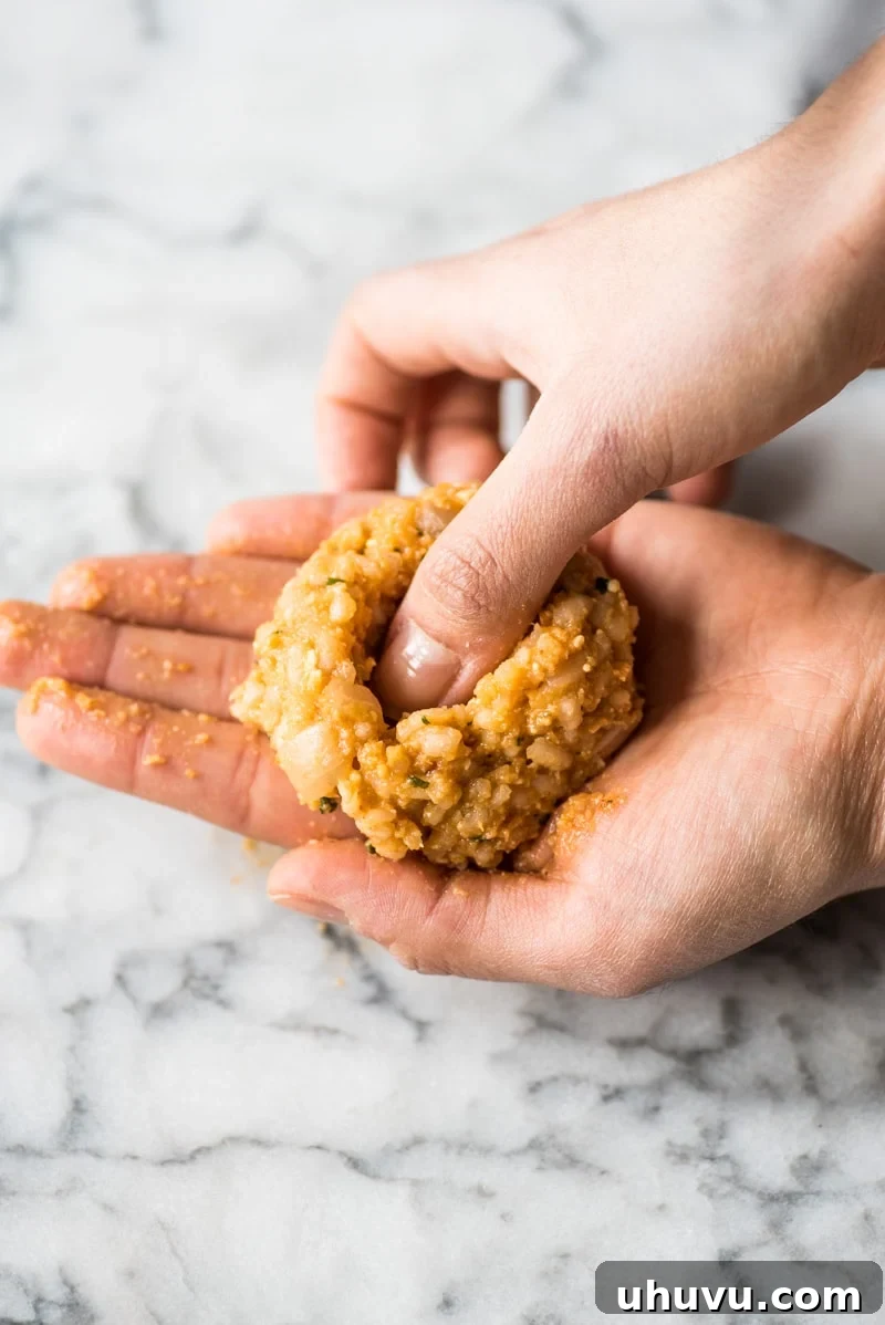 Zesty Fiesta Rice Bites 4 Gently pressing a thumb into the center of a formed rice ball to create an indent for the cheese filling.