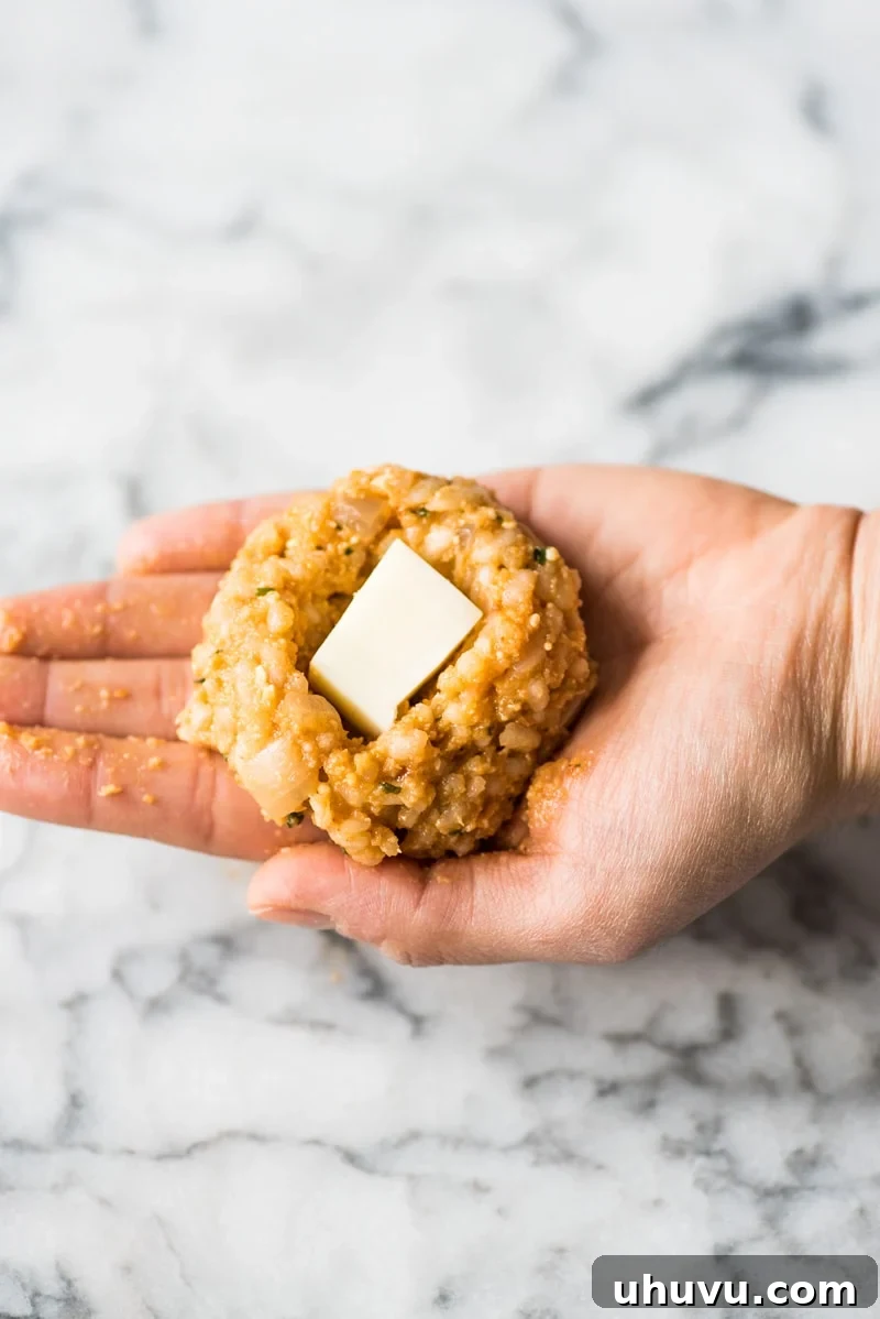 Zesty Fiesta Rice Bites 5 Carefully adding a cube of fresh mozzarella cheese into the indent of the arancini rice ball.