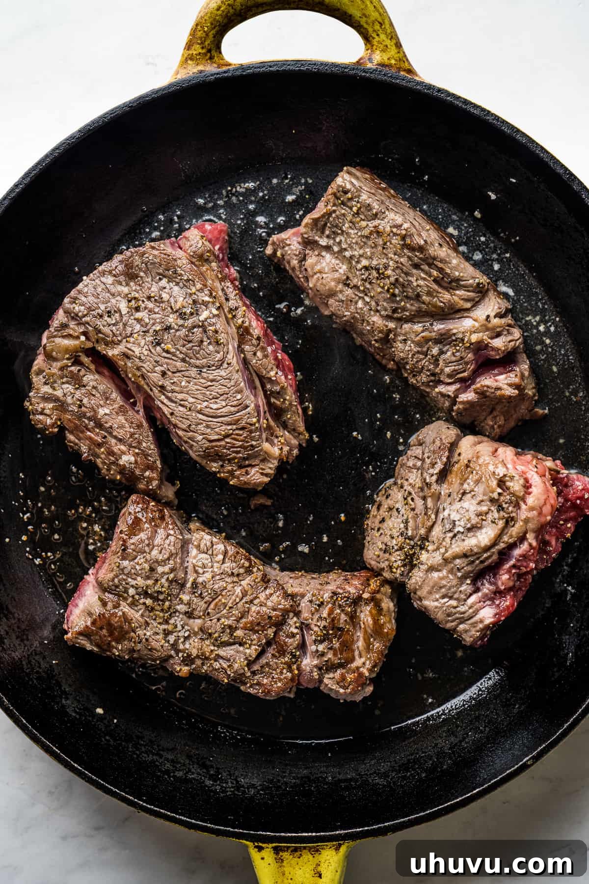 Melt-in-Your-Mouth Barbacoa 5 Large skillet with oil, searing four pieces of beef until browned on all sides, building rich flavor for barbacoa.