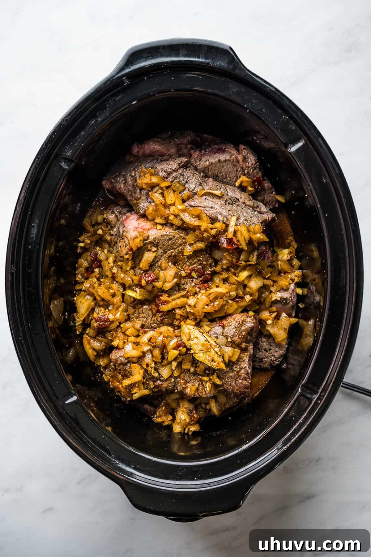 Melt-in-Your-Mouth Barbacoa 8 Seared beef chunks and the flavorful broth mixture are combined in a large slow cooker, ready for the long braising process.