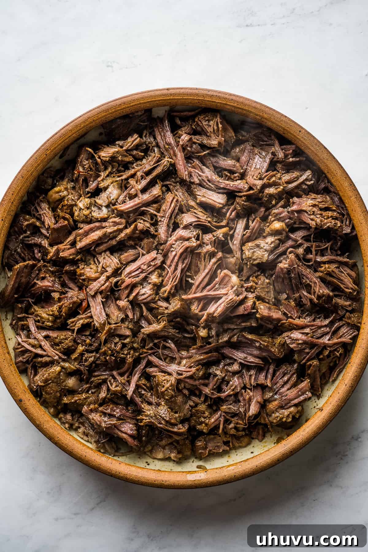 Melt-in-Your-Mouth Barbacoa 9 Cooked beef barbacoa placed in a large bowl, ready to be easily shredded with two forks.