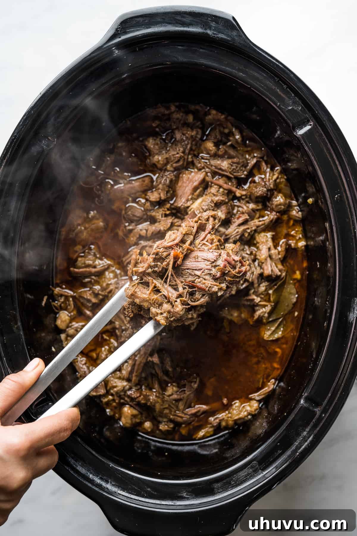 Melt-in-Your-Mouth Barbacoa 10 Shredded barbacoa beef returned to the slow cooker to soak up flavorful juices for ten minutes, ensuring maximum moisture and taste.