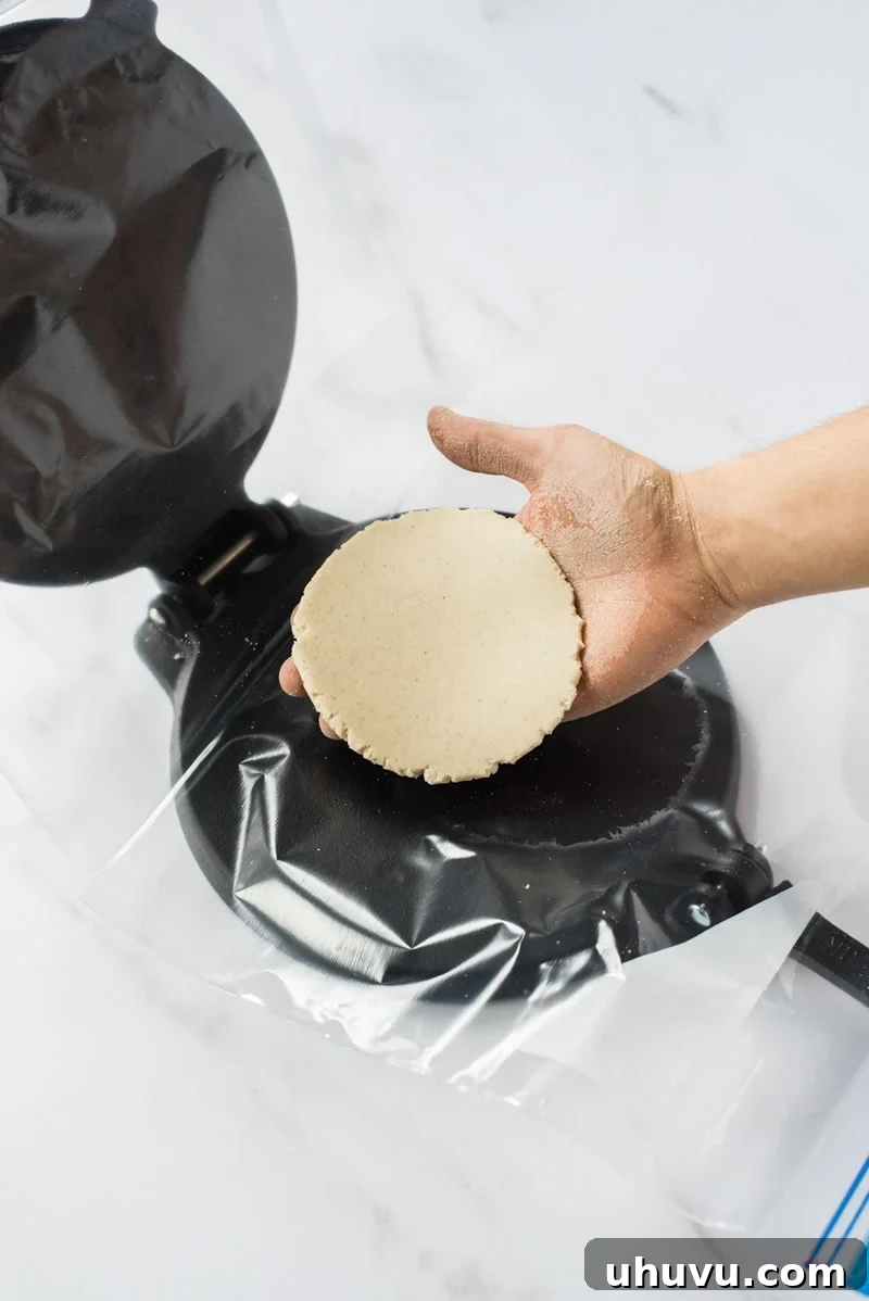 Homemade Gorditas: Authentic Mexican Stuffed Corn Cakes 8 Hand removing freshly pressed raw masa dough for corn tortilla
