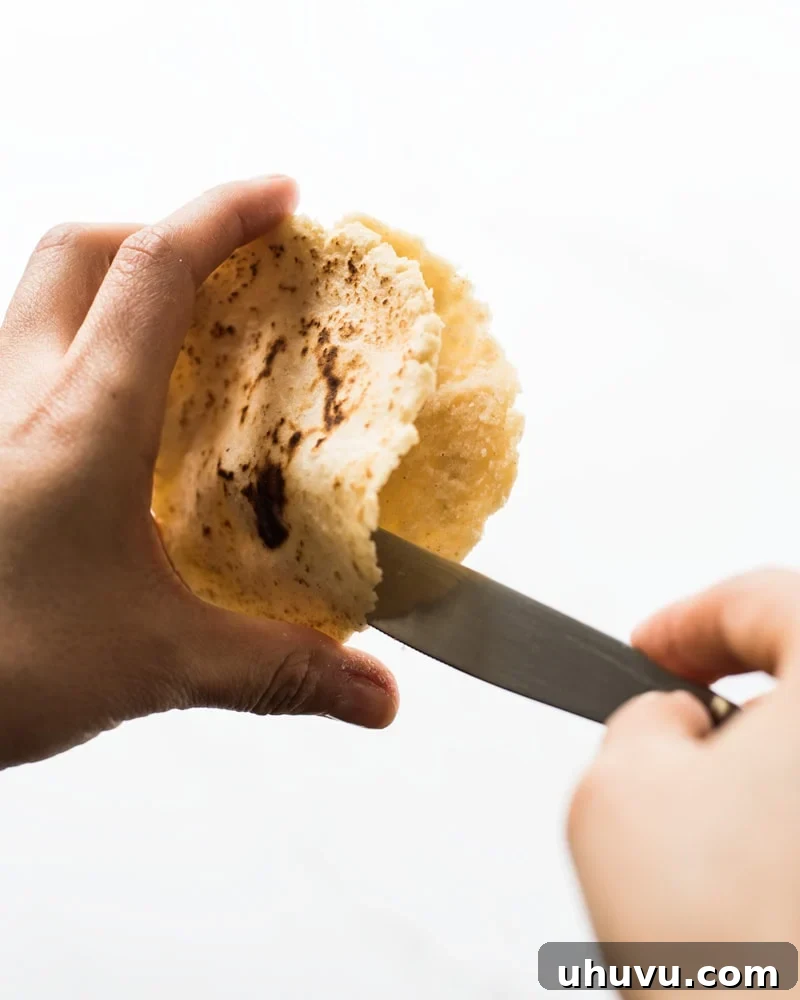 Homemade Gorditas: Authentic Mexican Stuffed Corn Cakes 10 Cutting open a gordita with a knife to reveal a little pocket inside