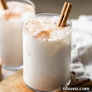A glass of horchata on a table garnished with ground cinnamon and poured over ice.