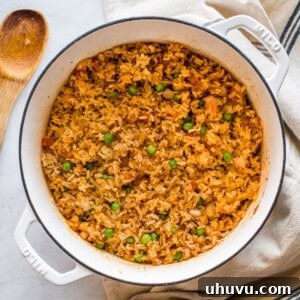 Cooked Mexican rice in a pot with peas mixed in.