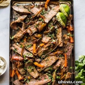Sheet pan steak fajitas topped with cilantro.