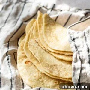 Homemade flour tortillas in a clean kitchen towel.