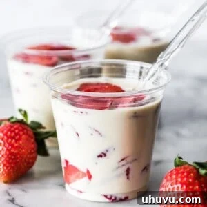 Fresas con Crema in a cup topped with fresh strawberries
