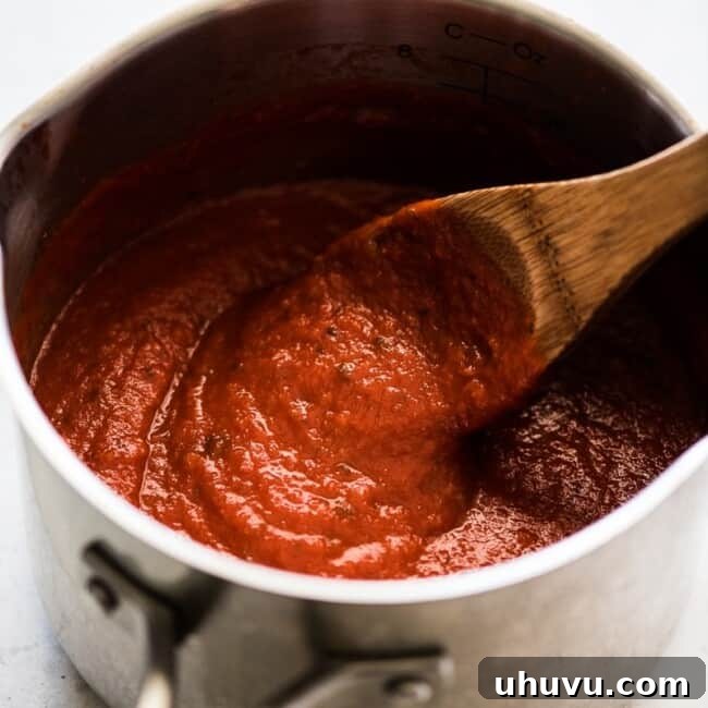 Quick Fiery Arrabbiata 5 An easy arrabiata sauce in a pot being stirred by a wooden spoon.