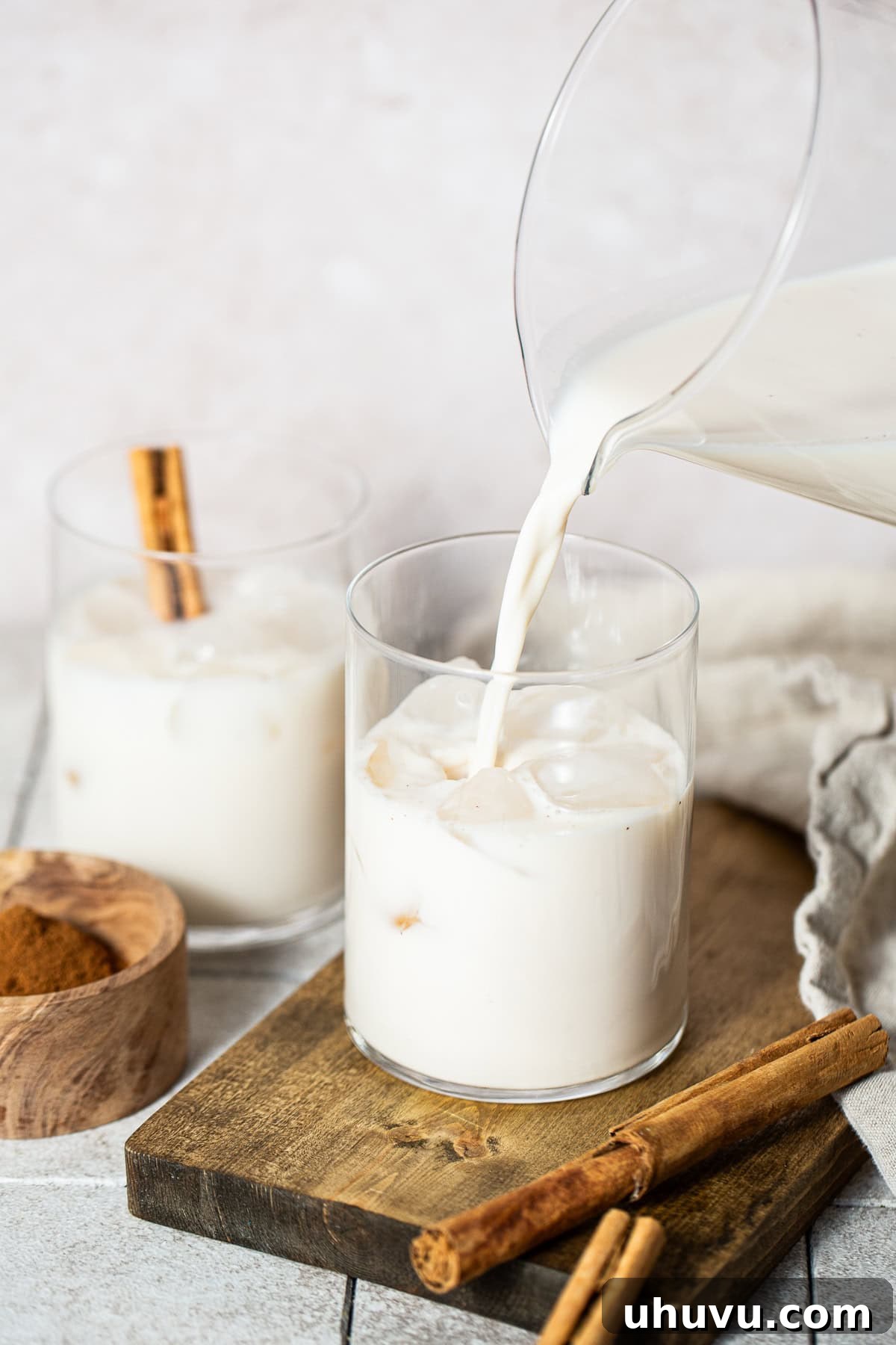 Horchata being poured over ice in glasses
