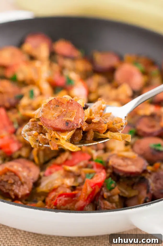 A spoonful of cooked Cabbage and Sausage, ready to be enjoyed