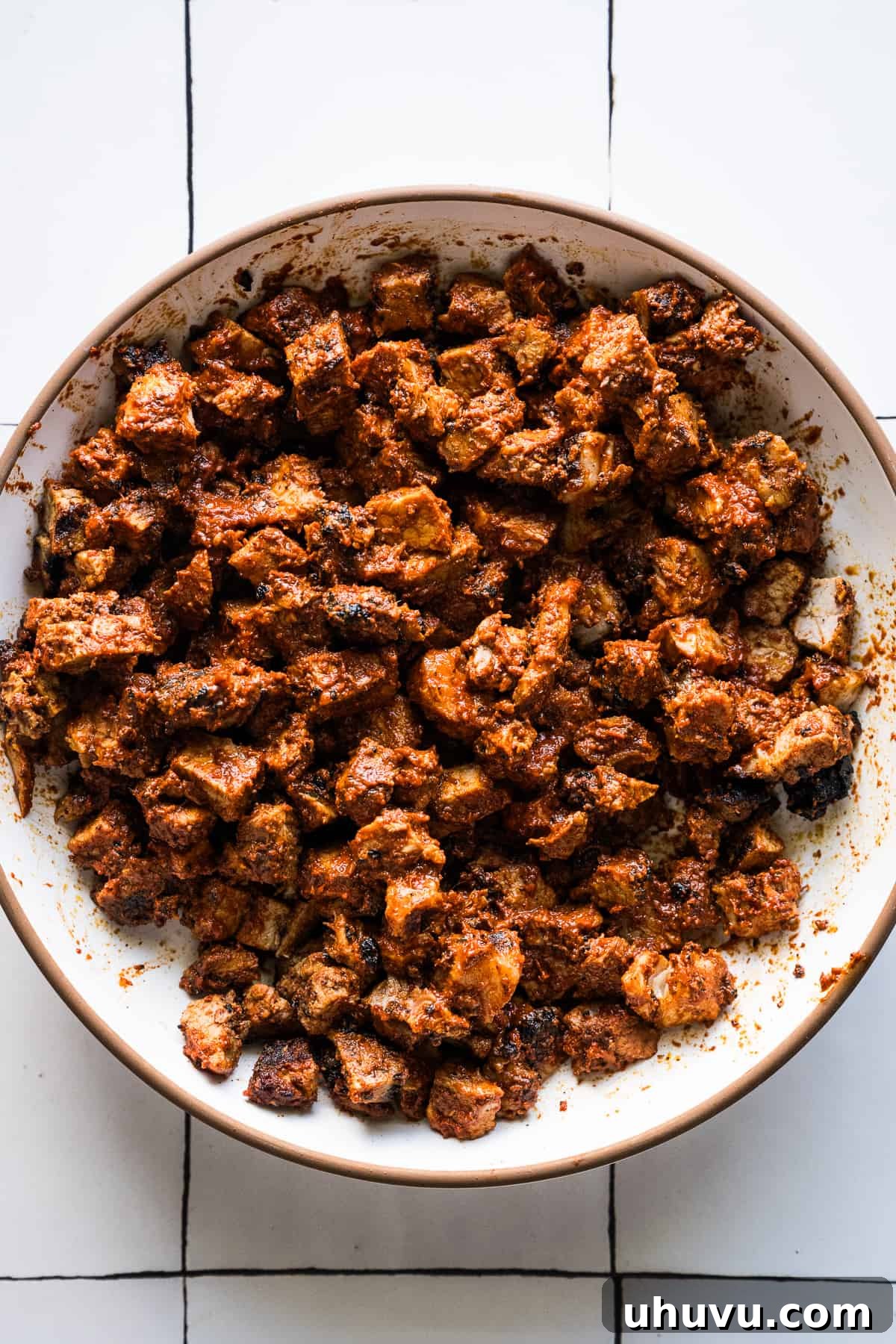 Diced Tacos al Pastor meat, perfectly grilled and chopped, resting in a bowl ready for assembly.