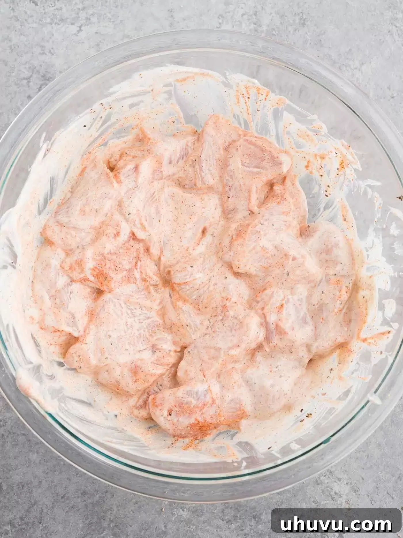 Marinating chicken with yogurt and spices in a bowl