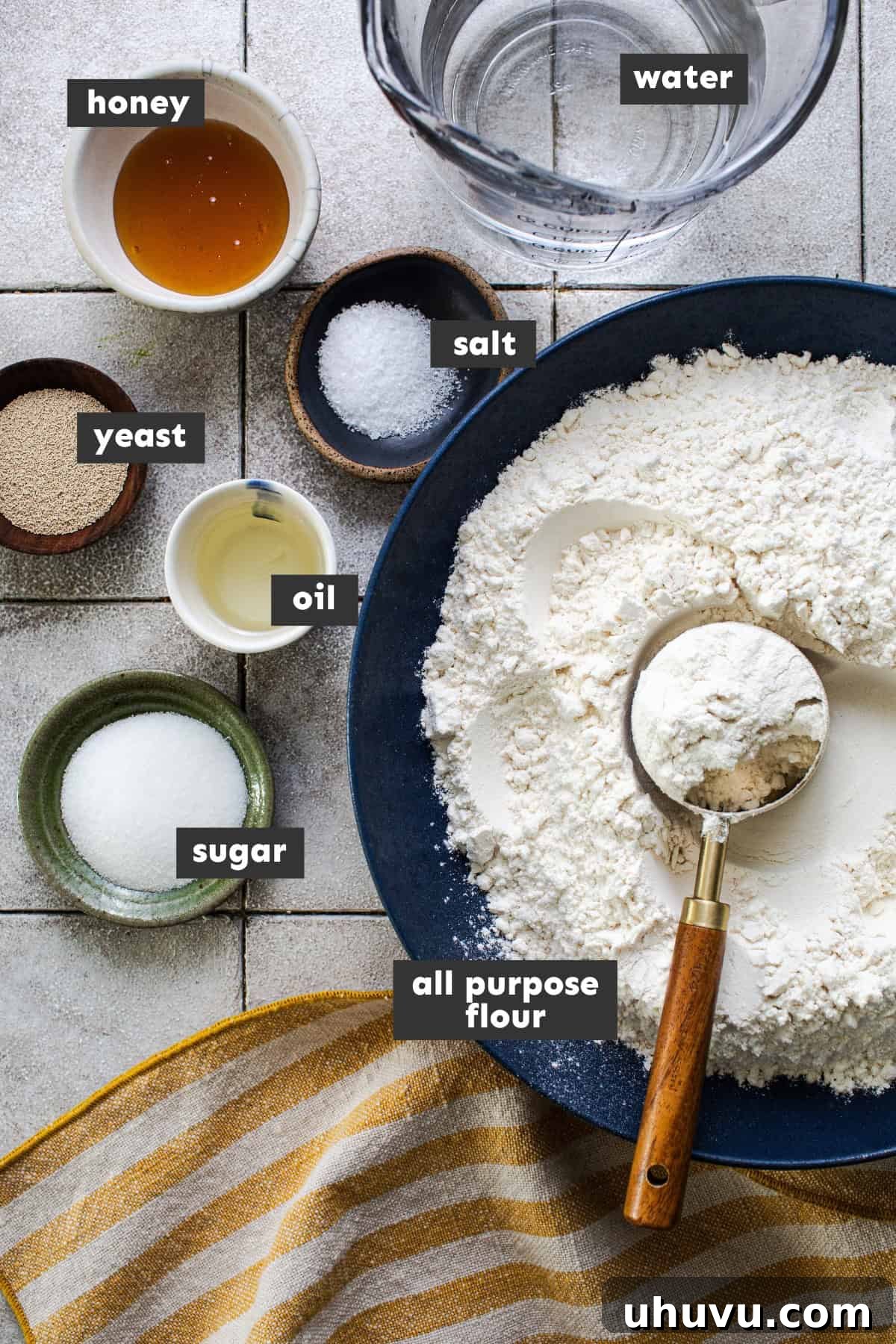 Ingredients for soft Telera bread rolls laid out on a wooden table.