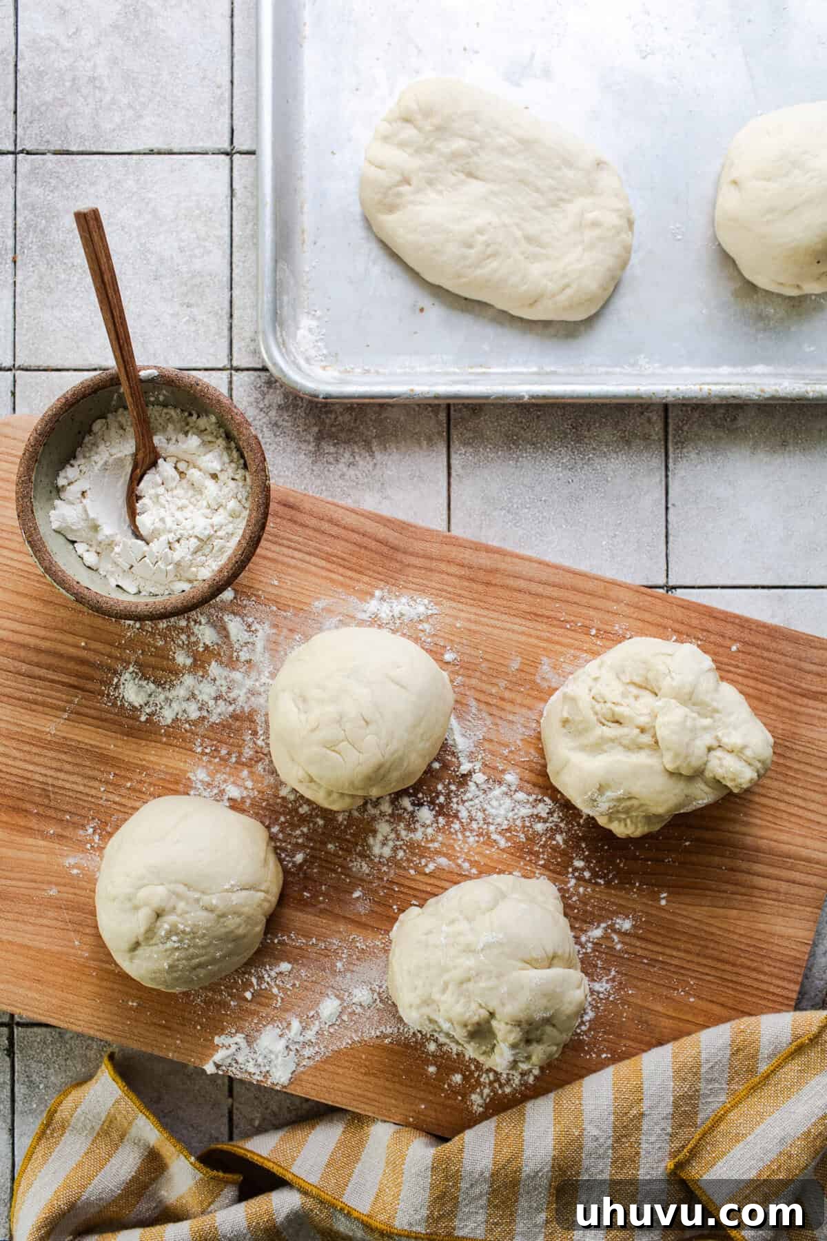 Dough being shaped into an oval on a floured surface.