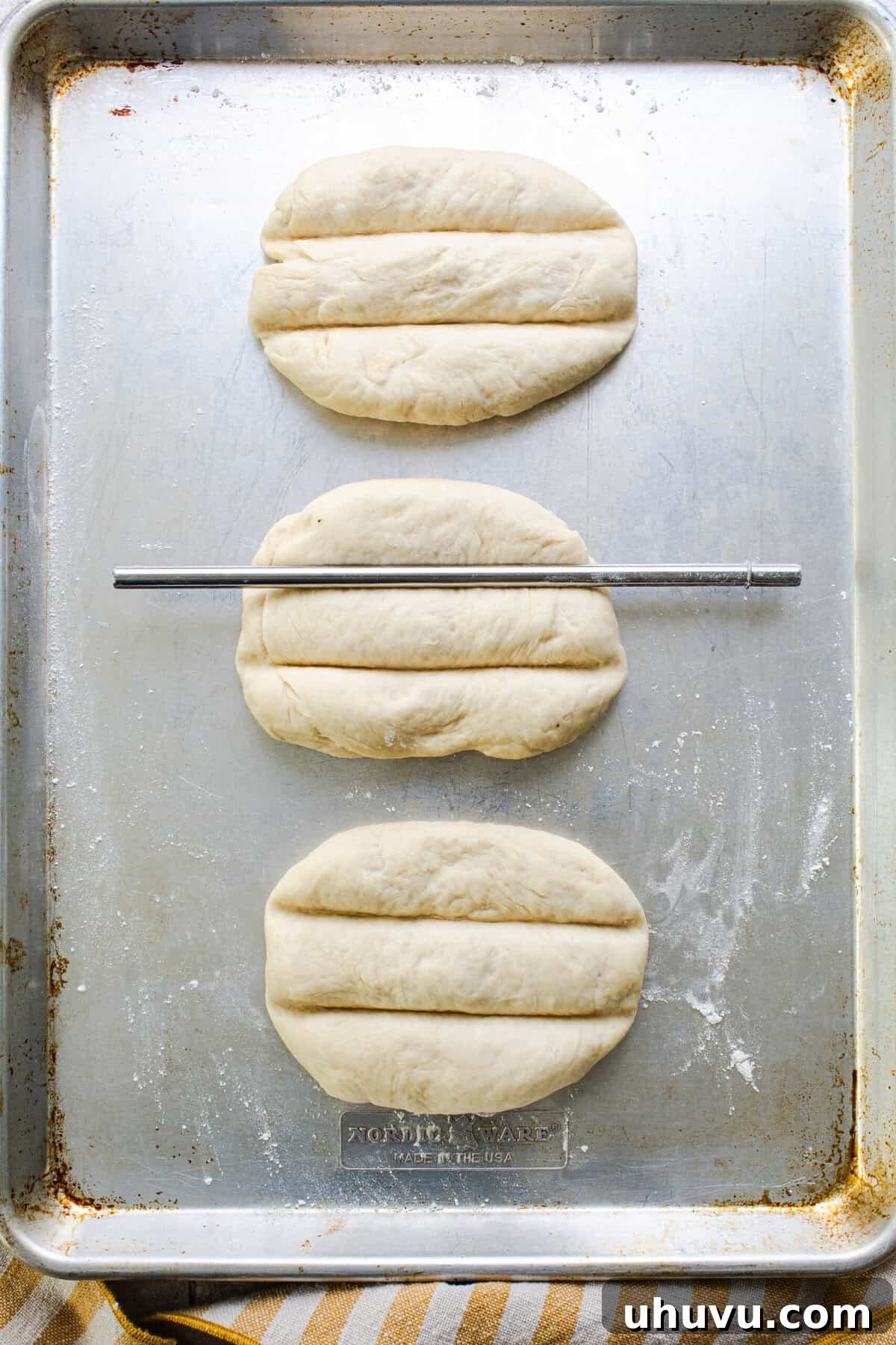 Using a butter knife to create the signature grooves in Telera bread dough.