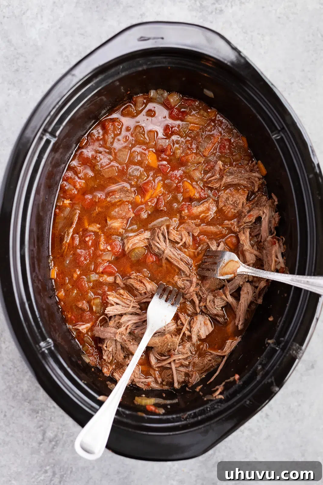 shredding beef ragu in the slow cooker