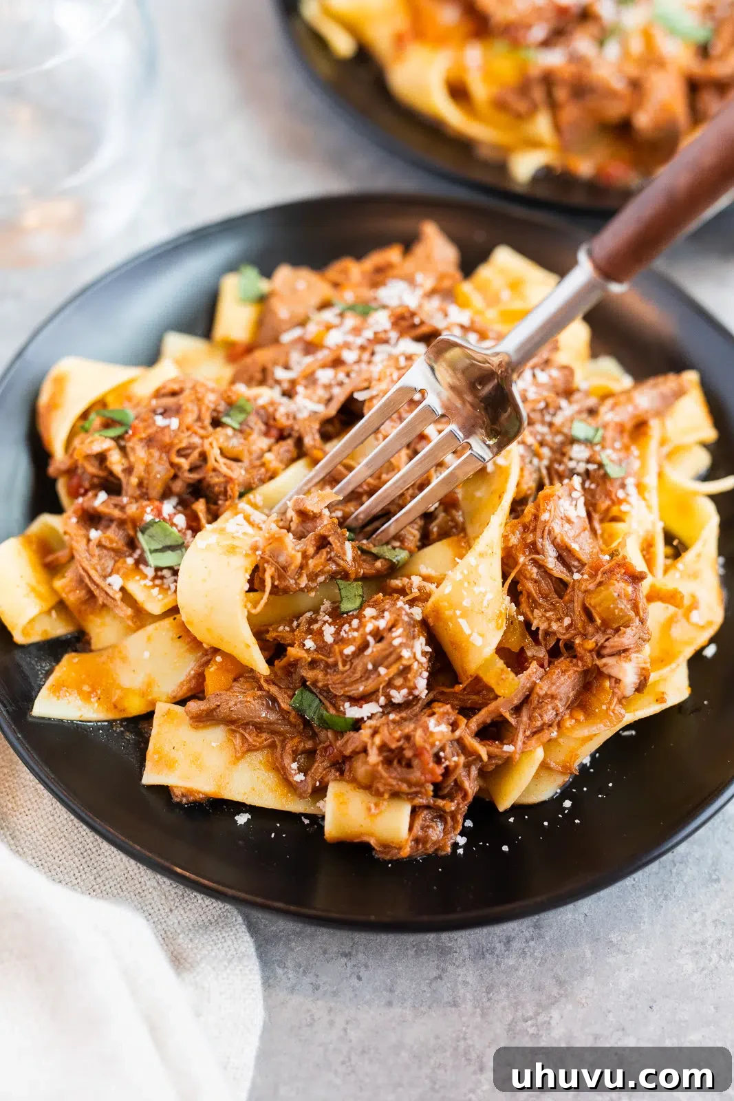 Slow Cooker Beef Ragu served over pappardelle pasta with shredded tender beef, rich tomato sauce, and freshly grated parmesan.