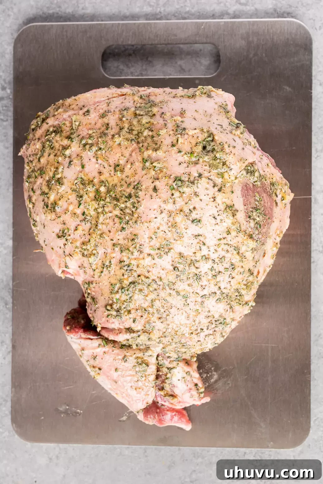 Boneless leg of lamb coated with garlic, rosemary, and thyme herb rub before roasting