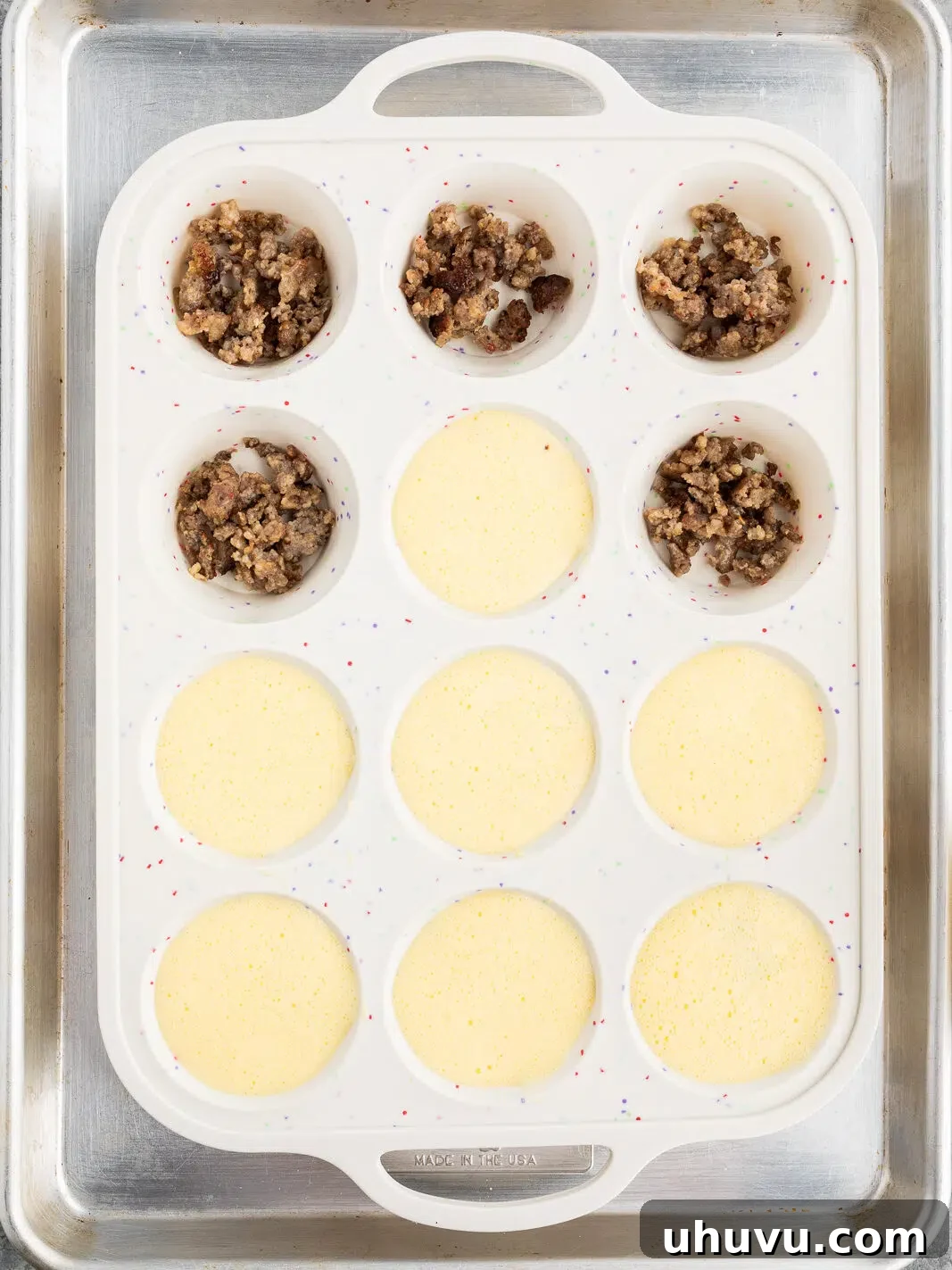 filling muffin cups with browned sausage and egg cottage cheese mixture