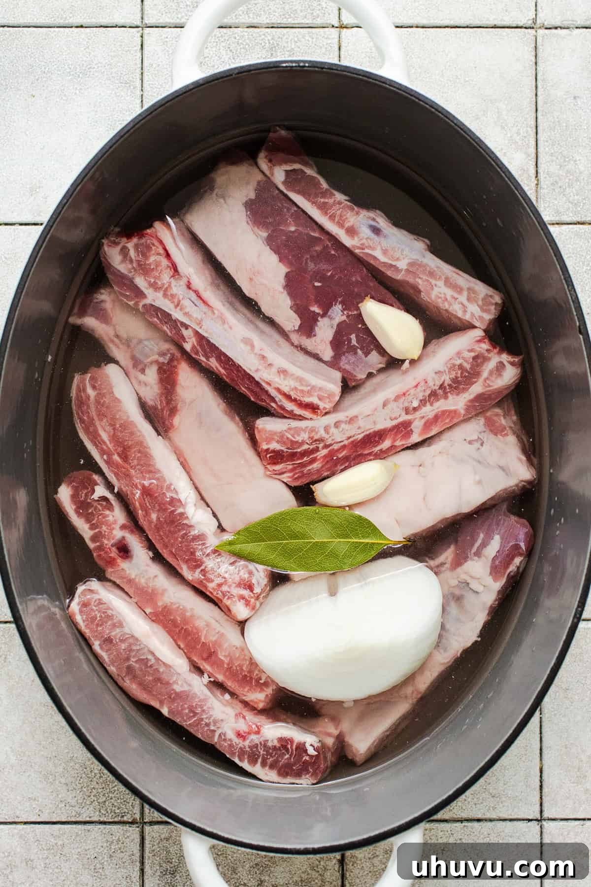 Morisqueta: Authentic Mexican Rice and Bean Dish Recipe 5 Pork ribs in a pot with onion, garlic, and a bay leaf.