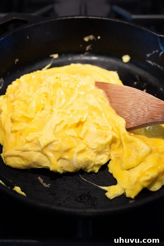 Cheesy Breakfast Quesadillas with Eggs and Salsa 4 scrambling eggs in a cast iron skillet
