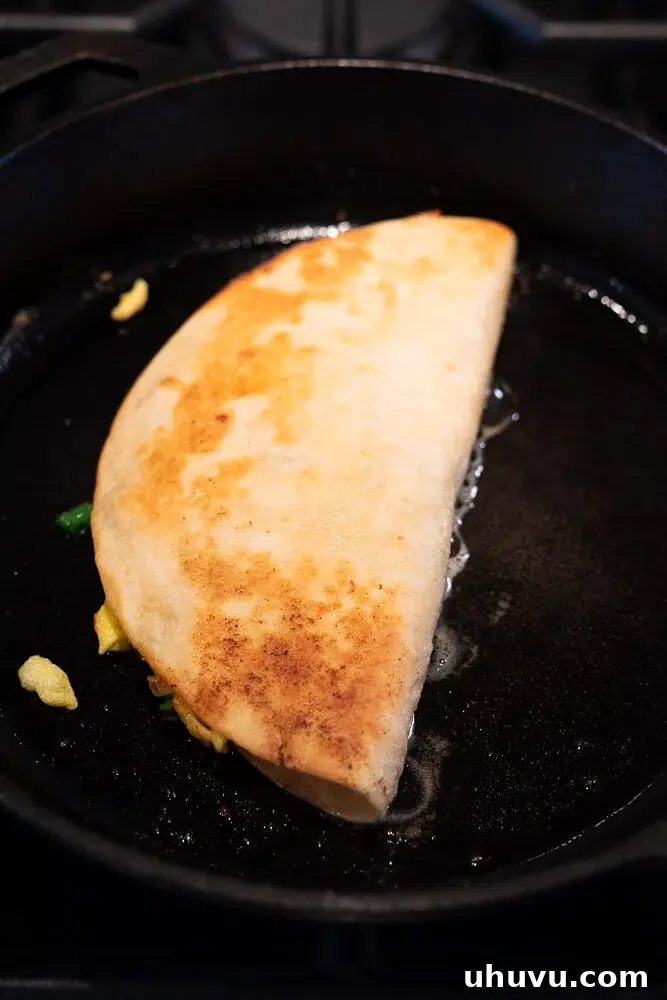 Cheesy Breakfast Quesadillas with Eggs and Salsa 6 pan frying bacon and egg quesadilla in a skillet
