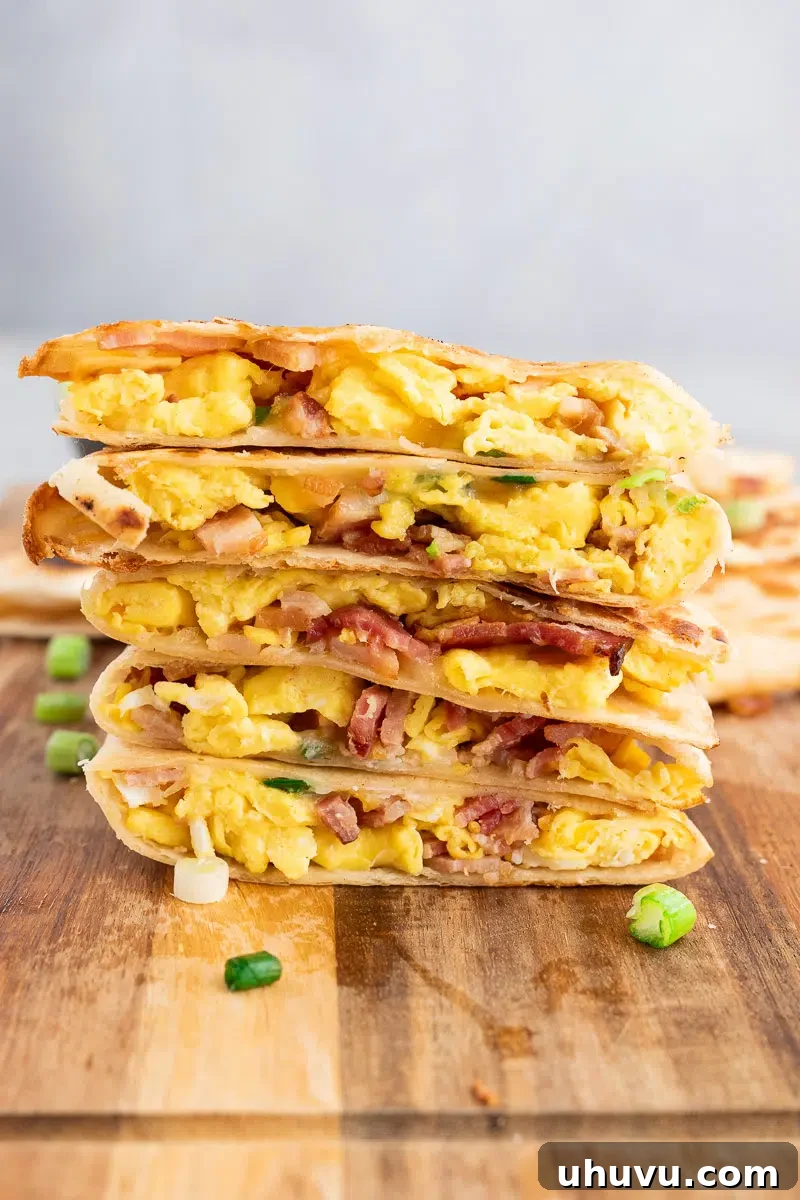 Cheesy Breakfast Quesadillas with Eggs and Salsa 8 stacked breakfast quesadillas wedges on a cutting board