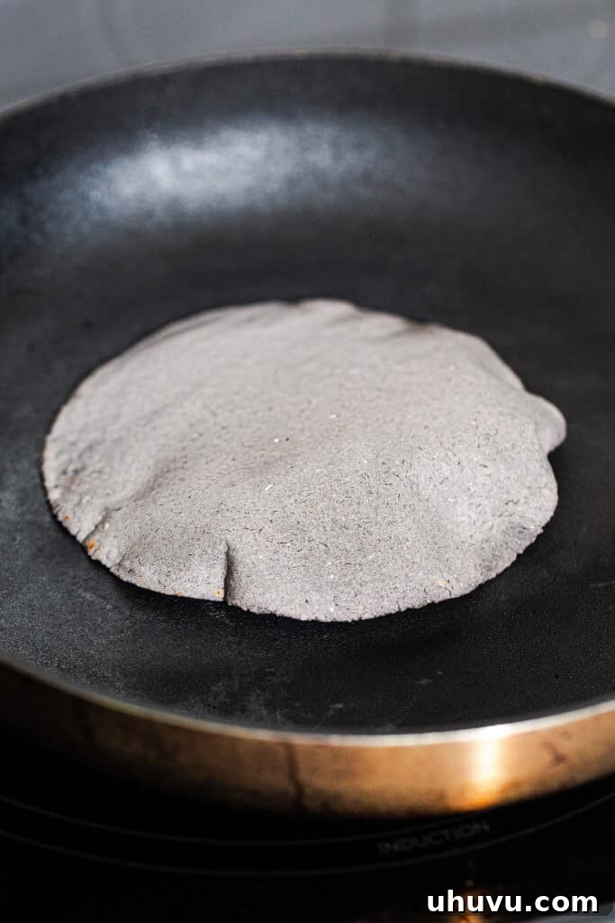 Authentic Blue Corn Tortillas Recipe 8 A blue corn tortilla cooking and puffing on a hot skillet.