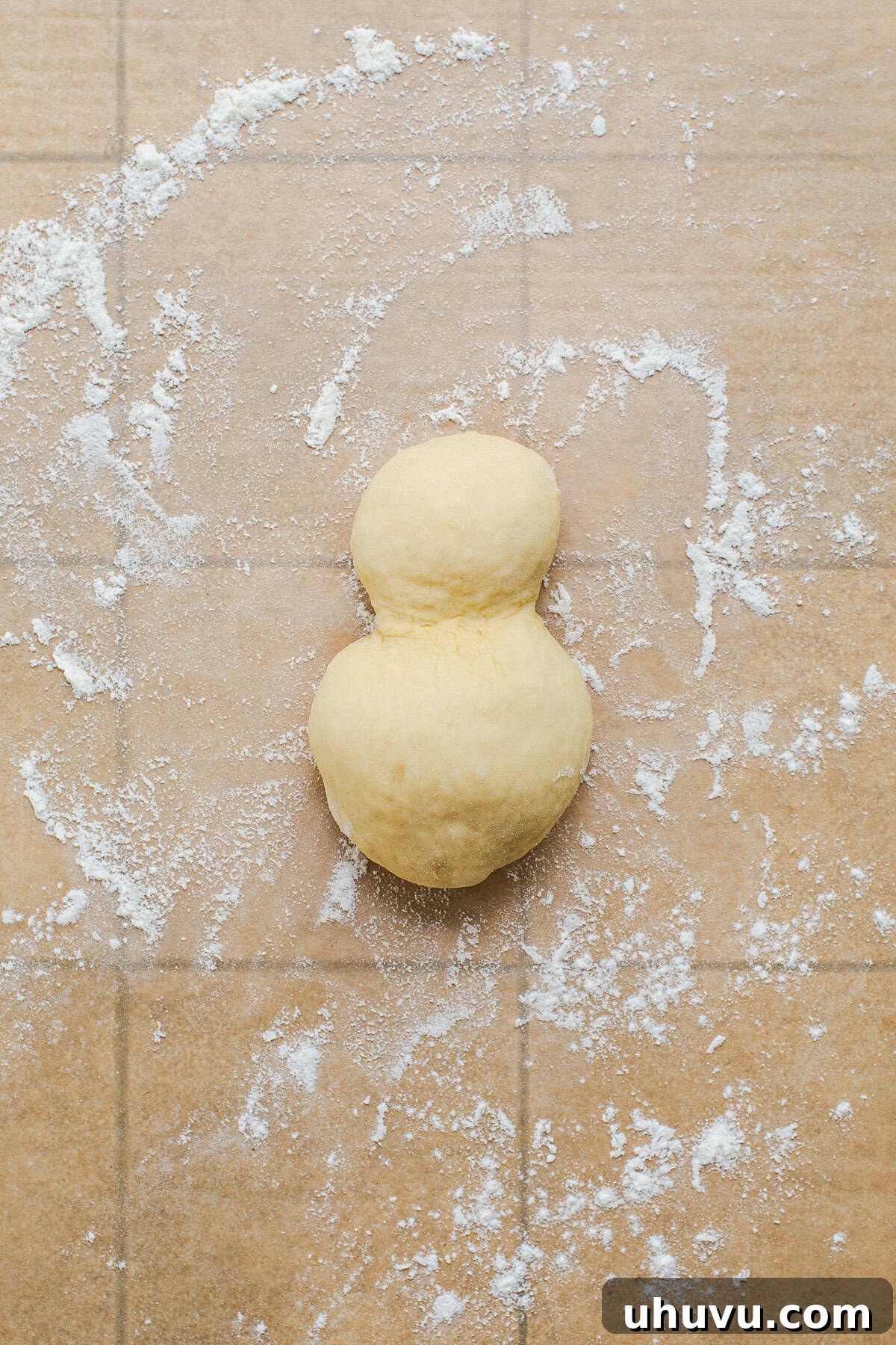 Authentic Cemita Buns: Mexican Sesame Sandwich Rolls 5 Cemita bun dough shaped into a snowman with a small ball joined to a bigger one.